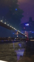 Whirling dervishes on a boat, Bosphorus Bridge glowing at night