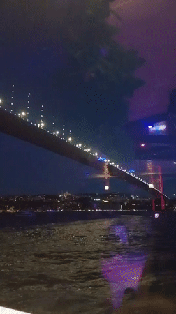 Whirling dervishes on a boat, Bosphorus Bridge glowing at night
