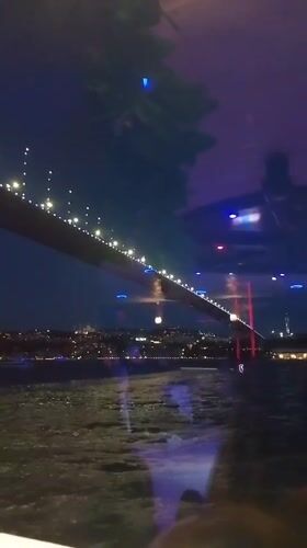 Whirling dervishes on a boat, Bosphorus Bridge glowing at night