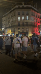 Bastille Day crowds celebrate on a Paris street at night
