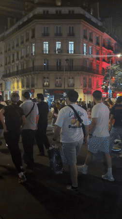 Bastille Day crowds celebrate on a Paris street at night