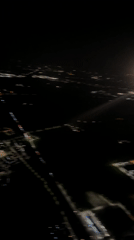 Aerial night footage captures illuminated Italian town from aircraft