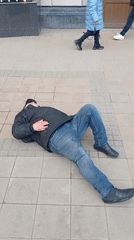 Man observed lying on sidewalk, bystanders present