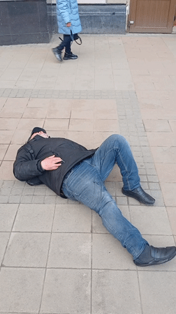 Man observed lying on sidewalk, bystanders present