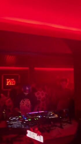 DJ performs afternoon set at red-lit Hangzhou nightclub