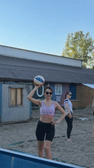 Woman practices beach volleyball in sunny Krasnoyarsk afternoon