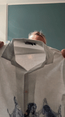 Woman displays white clothing item in Manchester living room