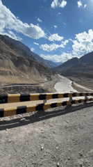 Winding mountain road ride through Ladakh's dry river valley