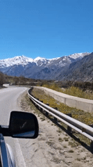 Car travels mountain road near Bylym, Russia under clear skies