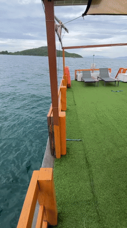 Jumping into the ocean off a turf-decked boat near Nha Trang
