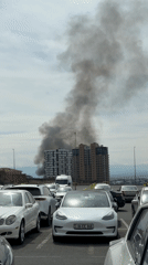 Dark smoke plume rises behind residential buildings in Yerevan