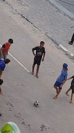 Street soccer game in Khan Yunis, kids playing amid urban surroundings