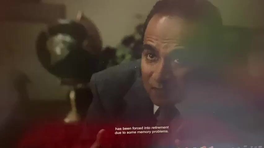 The video opens with a close-up of a man in a suit, appearing to speak, with a blurry globe in the background. The scene then transitions to a world map displayed on a screen, with several swastika symbols overlaid on different continents, including North America, South America, Africa, and Asia. A woman is pointing at the map with a stick, her mouth open as if speaking or exclaiming. Subtitles appear at the bottom of the screen in Spanish, and then in English, stating "has been forced into retirement due to some memory problems" and "And that's how Germany won the Second World War." The map appears to be a visual representation of a hypothetical scenario or an alternate history where Germany has achieved global dominance, marked by the presence of the swastikas. The overall tone suggests a presentation or a dramatic retelling of a historical event, possibly with a fictional or satirical twist, given the implied alternate outcome of World War II.