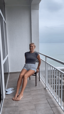 Woman performs morning exercises on balcony in Giachrypsh