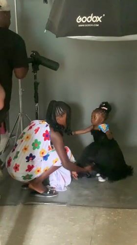 Photography session underway in Nigerian studio with woman, child