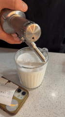 Person prepares whipped cream drink amid daisies in Novi Sad
