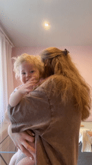 Woman holds toddler in pink room in Vladimir, Russia