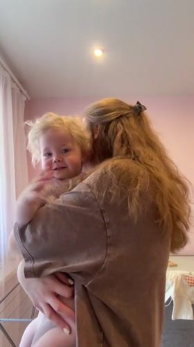 Woman holds toddler in pink room in Vladimir, Russia