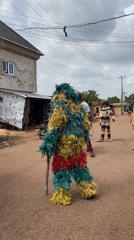 Traditional masquerade performer appears on Nigerian village street