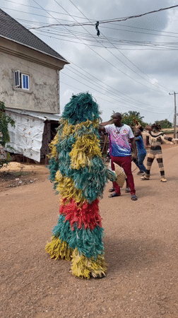 Traditional masquerade performer appears on Nigerian village street