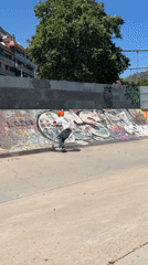 Scooter rider performs tricks at Spanish skatepark during sunny afternoon