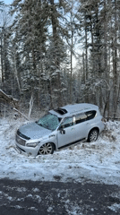 Silver SUV crashes in snowy roadside area in Russia