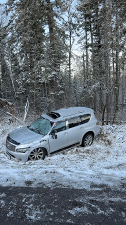 Silver SUV crashes in snowy roadside area in Russia