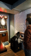 Man plays electronic darts in dimly lit Burgas room