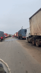 Semi-trucks line street in Karmajiji, Nigeria during morning hours