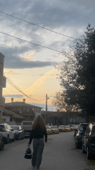 Woman walks residential street during Sofia dusk hours