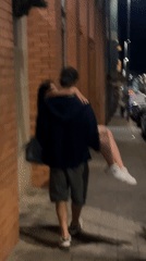 Man carries woman on Porto sidewalk at night