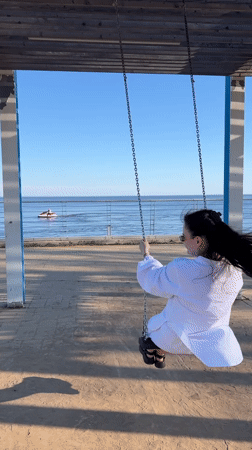 Woman on swing turns to smile in Laishevo