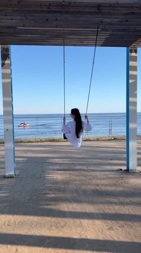 Woman on swing turns to smile in Laishevo