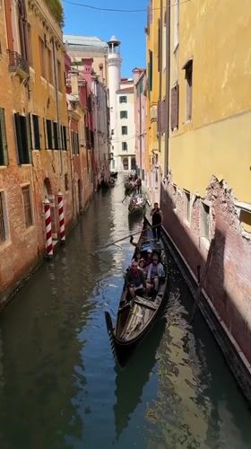 Tourists wave from gondolas in sunny Venice canal