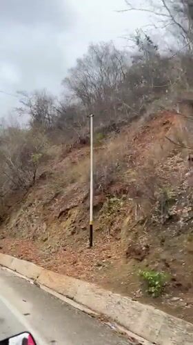 Roadside footage captures dry hillside vegetation in Tacarigua, Venezuela