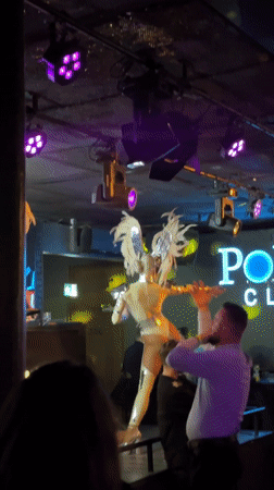 Costumed performers with feathered wings entertain nightclub crowd in Poland