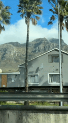 Table Mountain viewed through clouds from Cape Town roadside