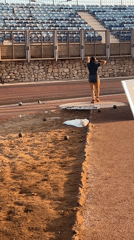 Shot put athletes train at dusk in an Arica stadium