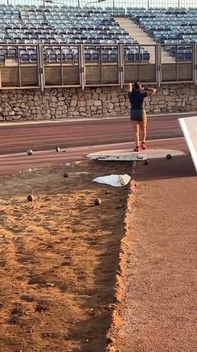 Shot put athletes train at dusk in an Arica stadium