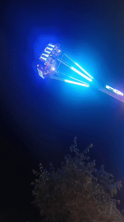 Nighttime amusement ride glows in blue and purple, Vienna