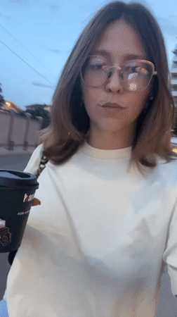 Woman with coffee cup walks through Podgorica streets