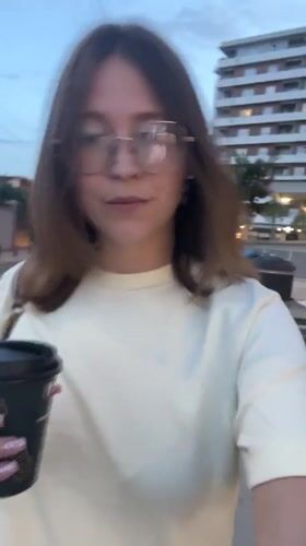 Woman with coffee cup walks through Podgorica streets