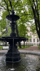 Visitor documents ornate fountain and monument in Saint Petersburg park