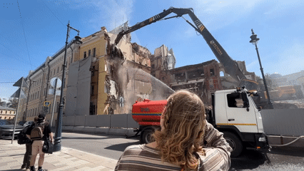 Building demolition underway under clear skies