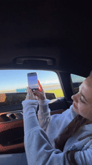 Woman photographs scenic drive through Yerevan with mountain backdrop