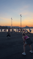 Evening fitness class conducts outdoor workout near water in Kazan