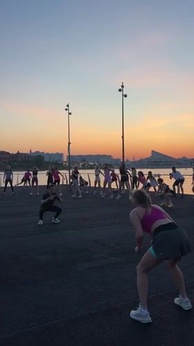 Evening fitness class conducts outdoor workout near water in Kazan