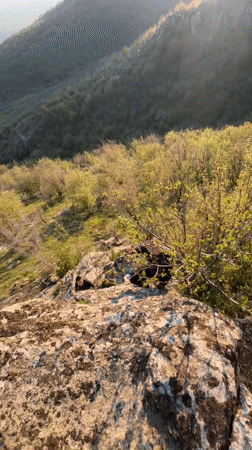 Hikers climb rocky hillside in Goritsa, Bulgaria