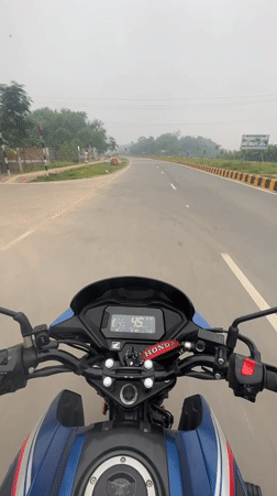 Motorcyclist rides Honda bike through Purbachal, Bangladesh at night