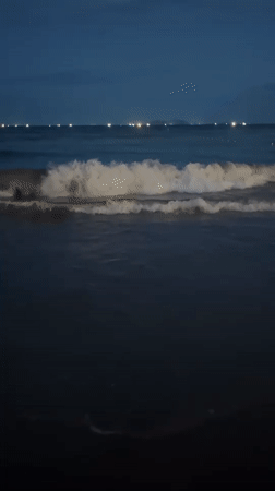 Evening on Đà Nẵng beach, waves and city lights